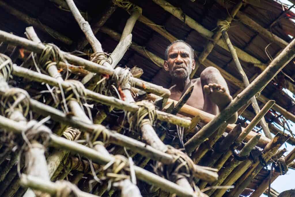 homme korowai dans maison