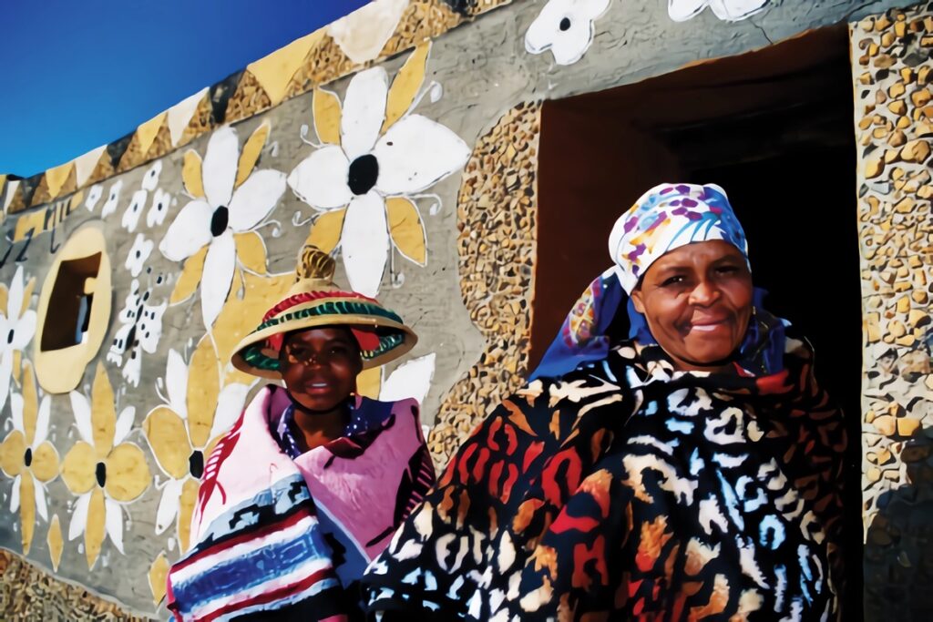 femmes basotho devant une maison décorée litema