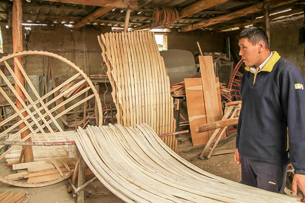 un homme construit les éléments en bois d'une yourte kirghize