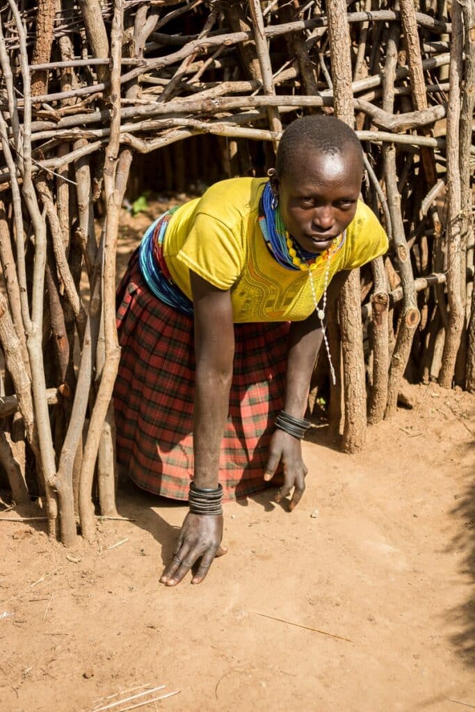 femme sortant d'une hutte karamojong
