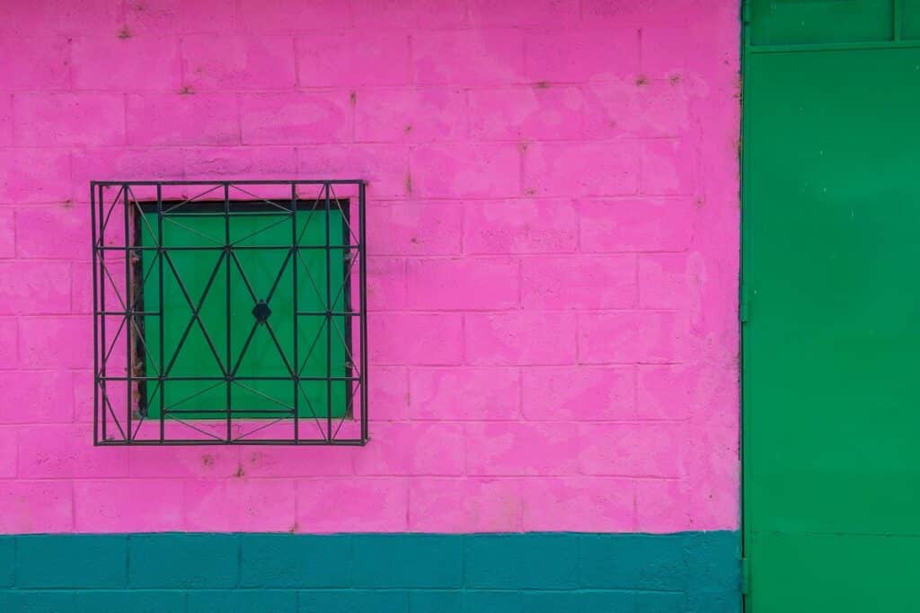façade colorée à Suchitoto

---

### Une architecture coloniale préservée

Les maisons de Suchitoto se distinguent par leurs murs épais en adobe, blanchis à la chaux, et leurs toits de tuiles en argile. Les façades donnent souvent sur la rue avec des portes en bois massif, tandis que des patios intérieurs apportent lumière et fraîcheur. Cette organisation héritée de l’époque coloniale espagnole reste remarquablement intacte. Beaucoup d’habitations ont conservé leurs balcons ouvragés, leurs fenêtres protégées par des grilles en fer forgé et leurs encadrements colorés, contrastant avec la blancheur des murs. Ces détails donnent à la ville une unité architecturale rare en Amérique centrale.

### Le rôle des maisons dans la vie sociale

Au-delà de leur esthétique, les maisons coloniales de Suchitoto sont le reflet d’une manière de vivre. Les patios servaient de lieu de rassemblement familial, mais aussi d’espace pour les fêtes et célébrations. Les rues pavées, bordées de ces demeures, sont devenues des espaces communautaires où se rencontrent habitants et visiteurs. Aujourd’hui encore, cette dimension sociale perdure : de nombreuses maisons restaurées accueillent des galeries d’art, des cafés ou des auberges, prolongeant l’usage de ces bâtiments comme lieux de rencontre et d’échanges.

---

Voulez-vous que je développe ces deux parties avec davantage de détails historiques (ex. restauration après la guerre civile, rôle du tourisme culturel), ou préférez-vous les garder sous forme synthétique comme ici ?