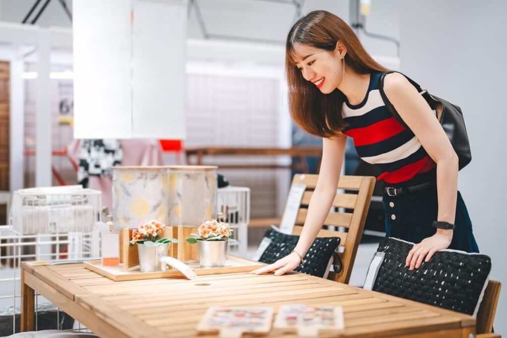 femme regardant une table dans un magasin de meubles