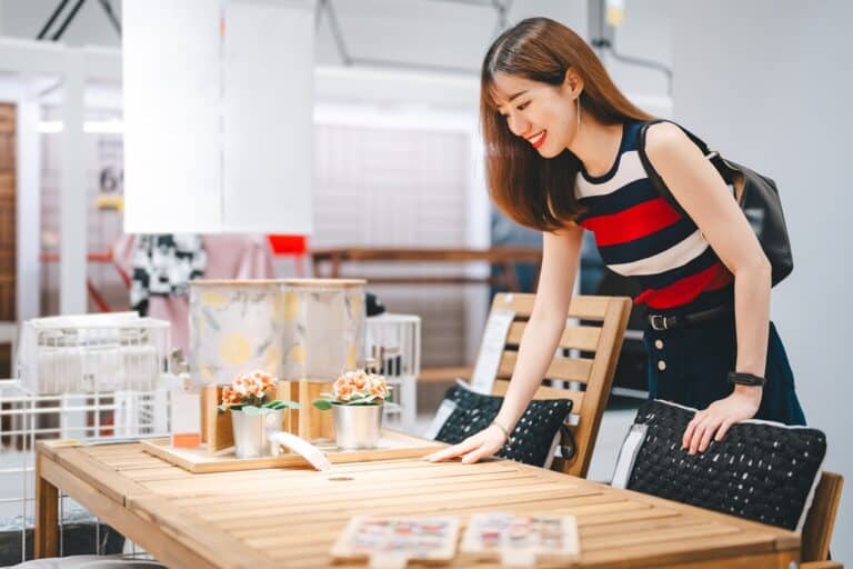 femme regardant une table dans un magasin de meubles