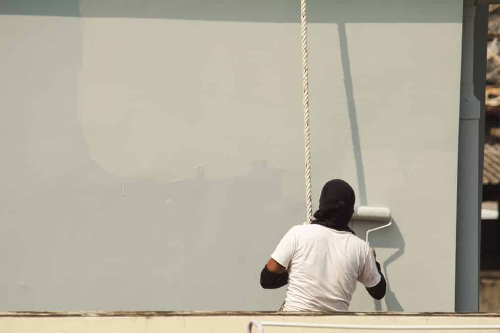 homme qui repeind une façade