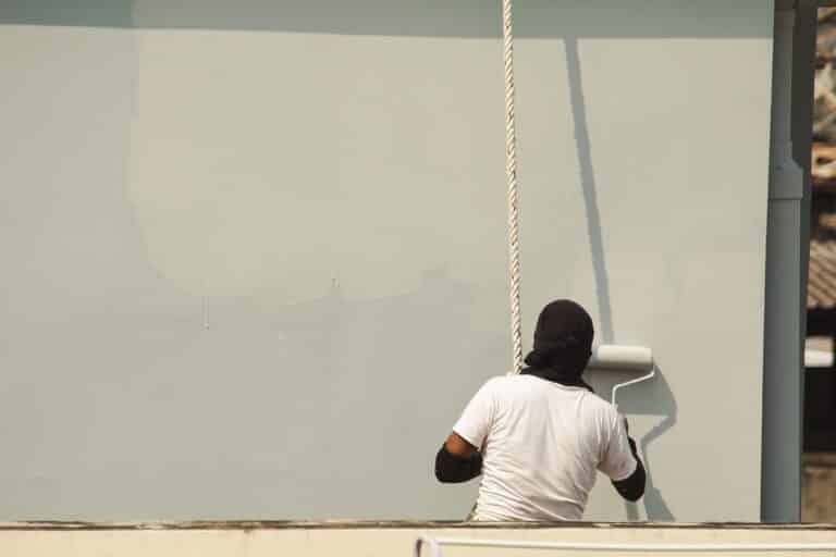 homme qui repeind une façade