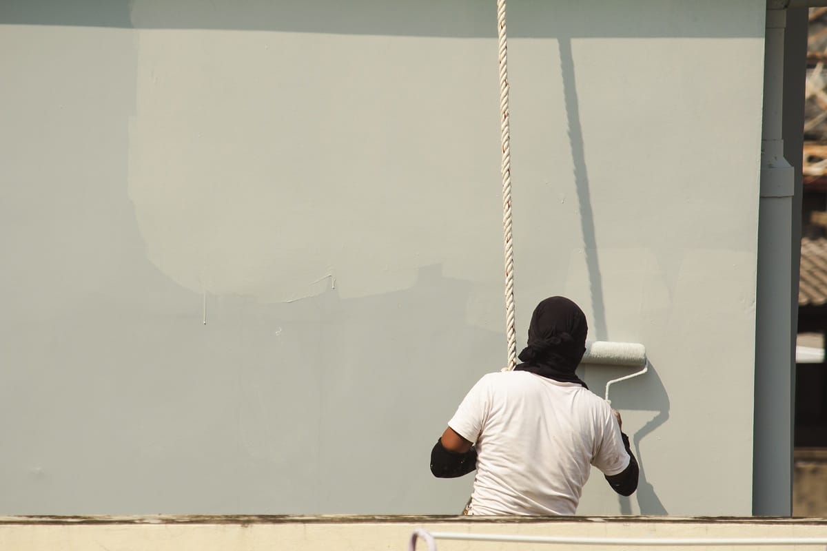 homme qui repeind une façade