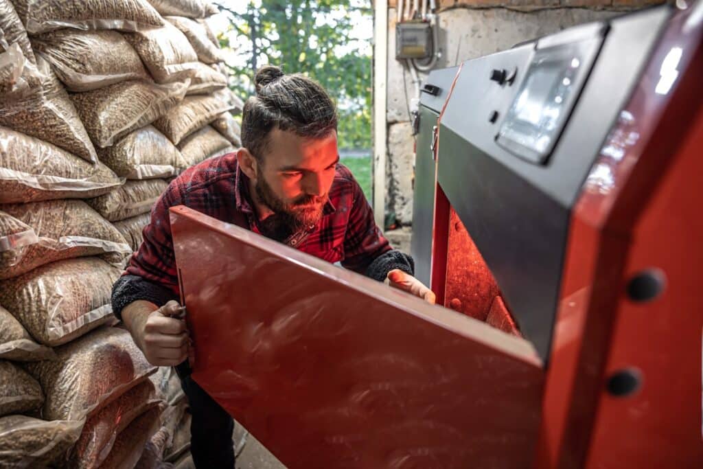 homme recharge sa chaudière à granulés