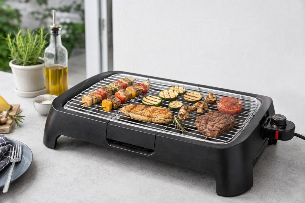 brochettes et viande en train de griller sur un barbecue électrique