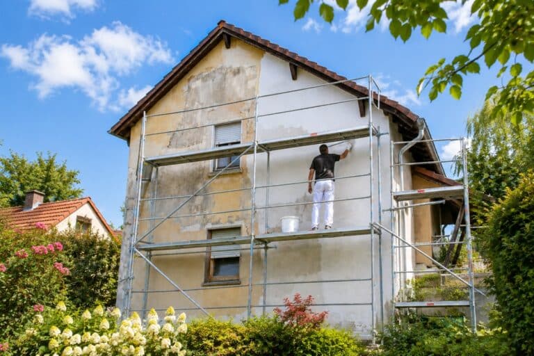 homme qui effectue un ravalement de façade sur un échaffaudage
