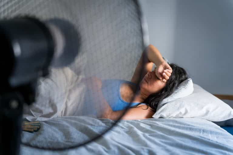 femme dormant devant un ventilateur