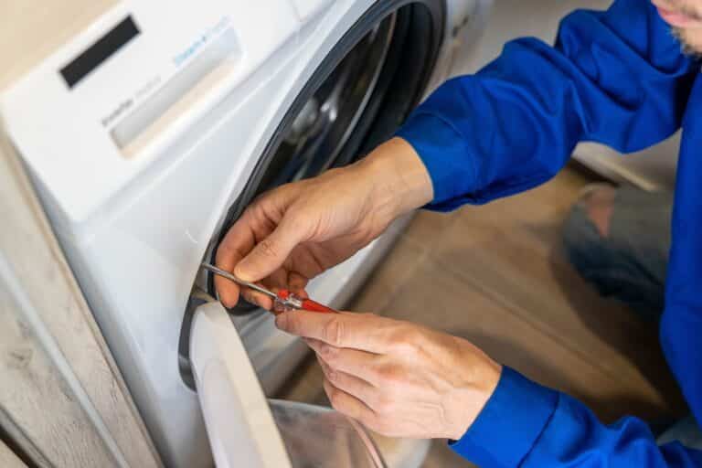 homme qui répare sa machine à laver