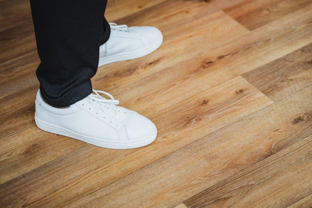 pieds avec baskets marchant sur un parquet contrecollé