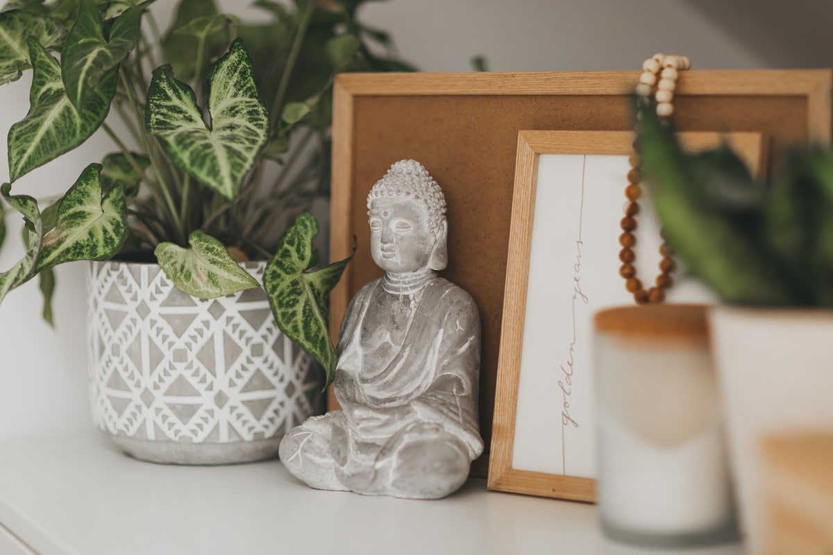 statue de bouddha sur un meuble avec de la déco