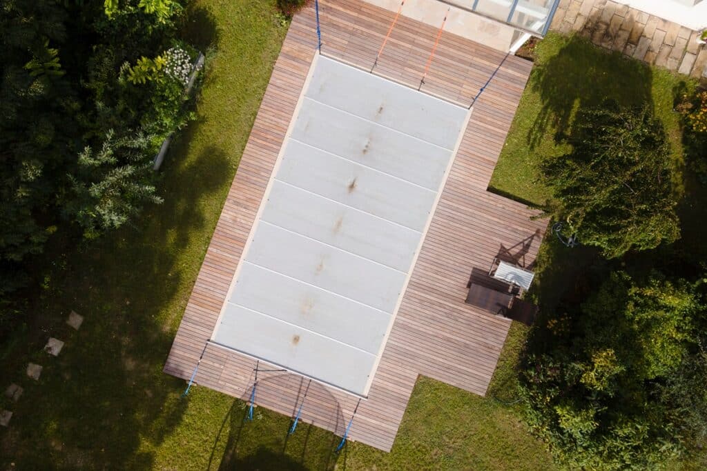 piscine vue du ciel avec une bâche à barres