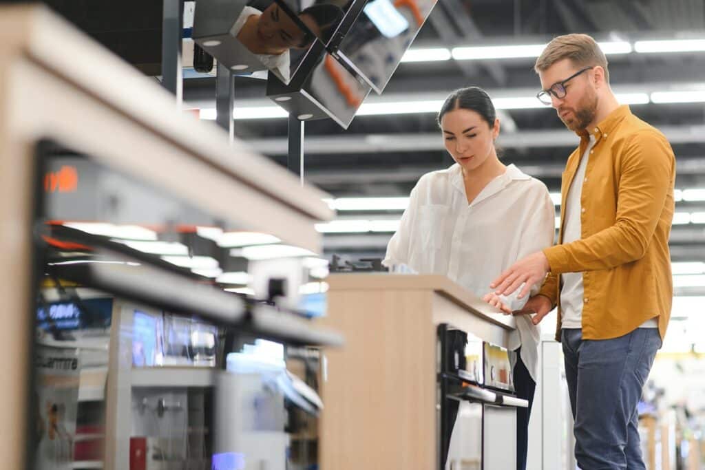couple regardant de l'électroménager dans un magasin spécialisé