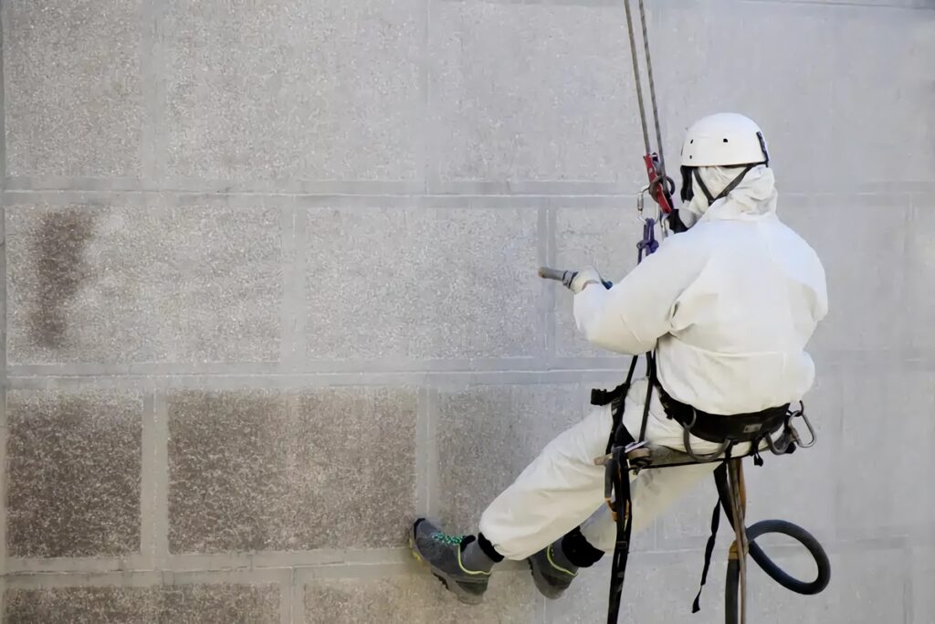 professionnel nettoie une façade de bâtiment