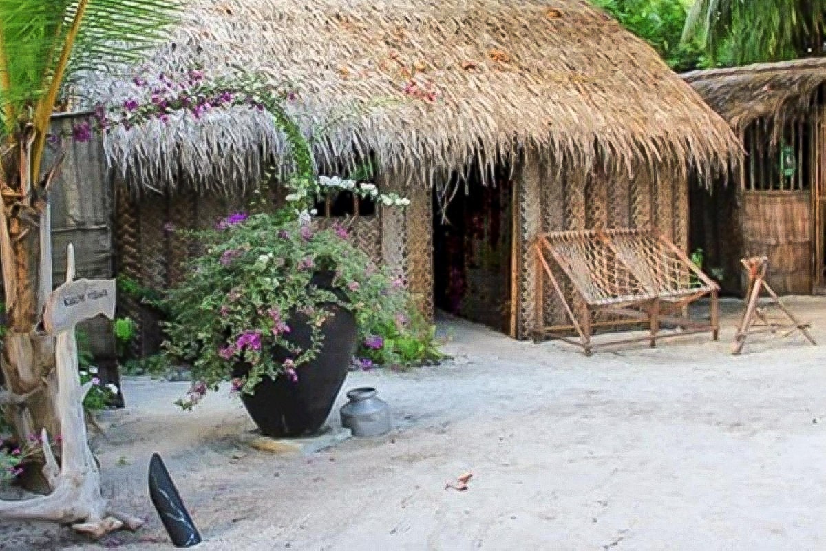 maison traditionnelle maldivienne en bois et toiture de palmes