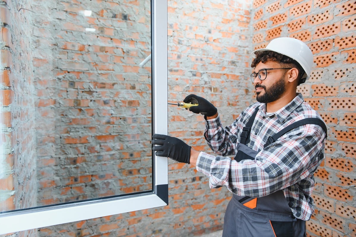 un artisan pose une fenêtre